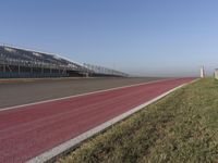 an empty track at a motorsports club with some red and white stripeing on it