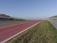 an empty track at a motorsports club with some red and white stripeing on it