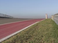 an empty track at a motorsports club with some red and white stripeing on it