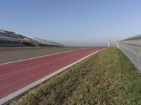 an empty track at a motorsports club with some red and white stripeing on it