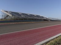 an empty track at a motorsports club with some red and white stripeing on it