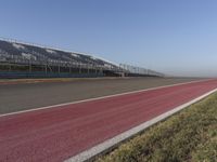 an empty track at a motorsports club with some red and white stripeing on it