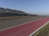 an empty track at a motorsports club with some red and white stripeing on it