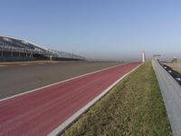 an empty track at a motorsports club with some red and white stripeing on it