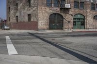 the shadow is on the street sign near the building in front of it and on the sidewalk are buildings