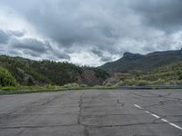 a mountain sits in the distance in a parking lot with a few trees and shrubbery