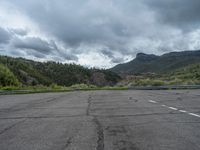 a mountain sits in the distance in a parking lot with a few trees and shrubbery