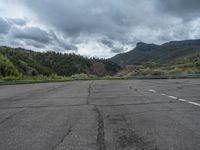 a mountain sits in the distance in a parking lot with a few trees and shrubbery