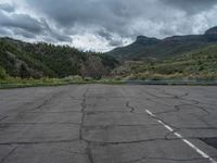 a mountain sits in the distance in a parking lot with a few trees and shrubbery