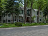 an empty street lined with trees and a mountain range in the distance in the back