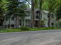 an empty street lined with trees and a mountain range in the distance in the back