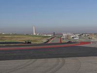 an empty track at a motorsports club with some red and white stripeing on it