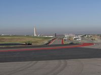 an empty track at a motorsports club with some red and white stripeing on it