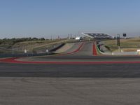 an empty track at a motorsports club with some red and white stripeing on it