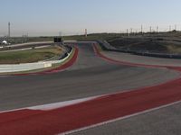 an empty track at a motorsports club with some red and white stripeing on it