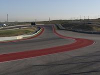 an empty track at a motorsports club with some red and white stripeing on it