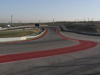 an empty track at a motorsports club with some red and white stripeing on it