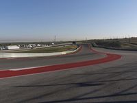 an empty track at a motorsports club with some red and white stripeing on it