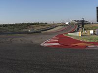 an empty track at a motorsports club with some red and white stripeing on it