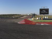 an empty track at a motorsports club with some red and white stripeing on it