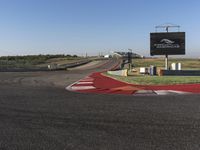 an empty track at a motorsports club with some red and white stripeing on it