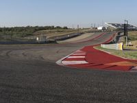 an empty track at a motorsports club with some red and white stripeing on it