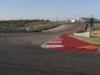 an empty track at a motorsports club with some red and white stripeing on it