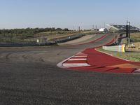 an empty track at a motorsports club with some red and white stripeing on it