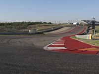 an empty track at a motorsports club with some red and white stripeing on it