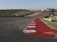 an empty track at a motorsports club with some red and white stripeing on it