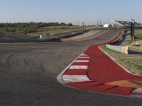 an empty track at a motorsports club with some red and white stripeing on it