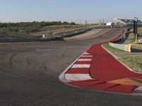 an empty track at a motorsports club with some red and white stripeing on it