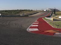 an empty track at a motorsports club with some red and white stripeing on it