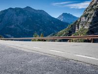 a road with a sign on the side of it next to a body of water with mountains in the background