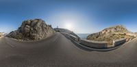 a picture of a view from a fish eye lens on an asphalt road with cliffs on both sides and a blue sky