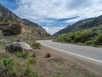 a car driving down a rural winding road in the mountains of the american southwest on a sunny day