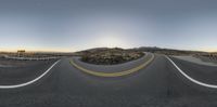 an empty mountain road with mountains and a sky background that has some clouds in the sky