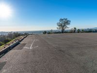 an empty parking lot is seen on a bright day on the hill top of a mountain