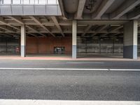 a empty car parking lot next to an overpass and a street corner in a urban area