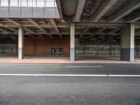 a empty car parking lot next to an overpass and a street corner in a urban area