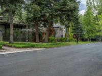 an empty street lined with trees and a mountain range in the distance in the back