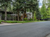 an empty street lined with trees and a mountain range in the distance in the back