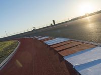 an orange and white racing track with red and white strips on the front corner of the track