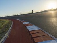 an orange and white racing track with red and white strips on the front corner of the track