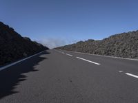 the desert road is lined with lava on either side of the highway, and many lavas are coming out from a large hill