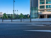 an empty road with a street sign at the curb in front of an office building