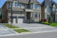 driveway is paved with brick blocks, and two doors are shown on either side of the driveway