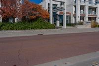 a person walking across the street near an empty parking lot holding a red fire hydrant