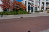 a person walking across the street near an empty parking lot holding a red fire hydrant