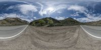 an upside down shot of the intersection of a rural road and mountain range as seen from a fish eye lens